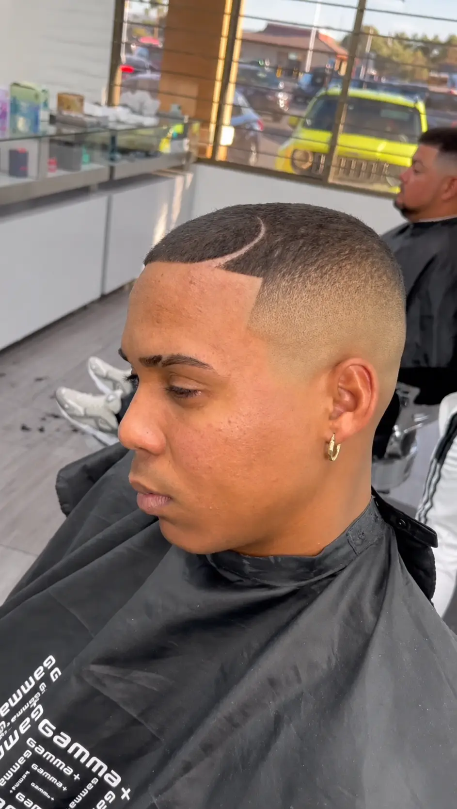 Blonde textured top with a sharp fade and V-shaped razor design on the nape
