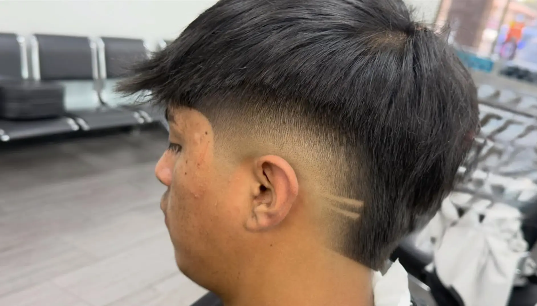 Mohawk fade with two horizontal razor lines cut into the side
